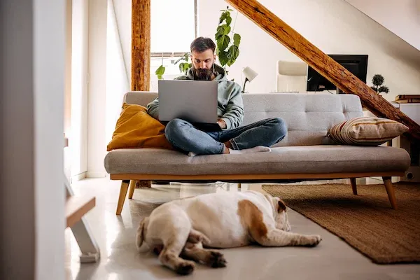 man using laptop on couch